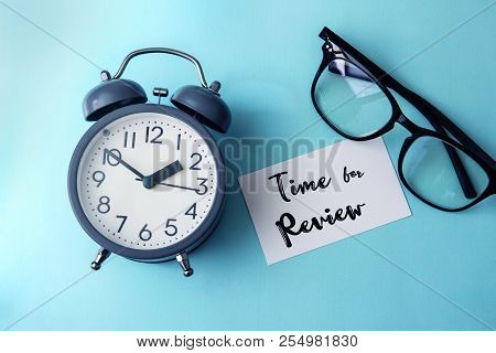 Time Concept With  Paper Note Of Time Fo Review  Message , Alarm Clock With Reading Eyeglasses Decor