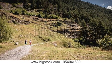 Hikers Climbing A Mountain Path In The Pyrenees In France