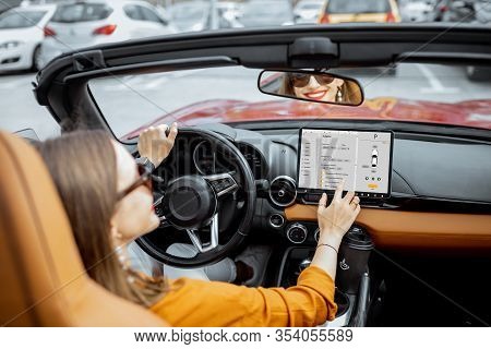Cheerful Woman Controlling Car With A Digital Dashboard, Switching Autopilot Mode While Driving A Ca