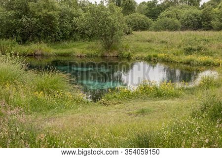 Blue Water Source Coming Up At The Bottom Of A Small Lake
