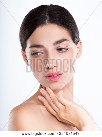 Portrait of beautiful young brunette woman with clean face. Beautiful face of young adult woman with clean fresh skin - isolated on white. Front portrait of woman with beauty face. Beauty concept 