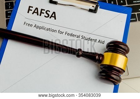 Fafsa. Student Aid Concept. Application Form Of Document On The Table With Wooden Hammer Isolated.