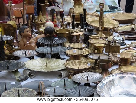 Flea Market Merchandise Out On Street - Brass, Bronze, And Gunmetal Color Candle Holders In Shape Of