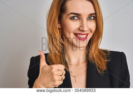 Close up of caucasian elegant business woman over isolated background happy with big smile doing ok sign, thumb up with fingers, excellent sign