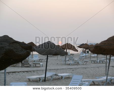 Solen stiger över en cafébar strand