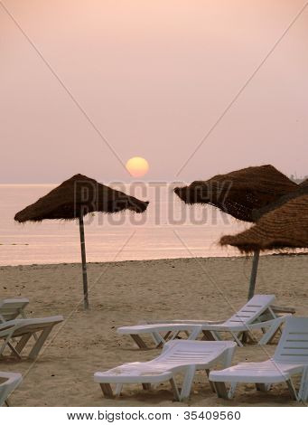 Solen stiger över en cafébar strand