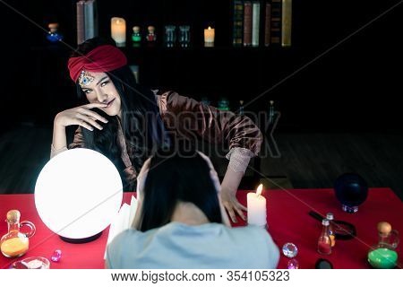 The Fortune-telling Woman Is Predicting The Fortune For A Beautiful Asian Woman By A Gypsy Card. It 
