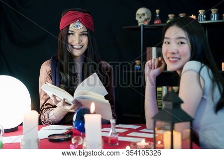The Fortune-telling Woman Is Predicting The Fortune For A Beautiful Asian Woman By A Gypsy Card. It 