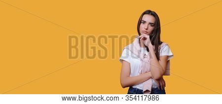 Thoughtful Caucasian Lady With Black Hair Posing On A Yellow Background Will Freespace