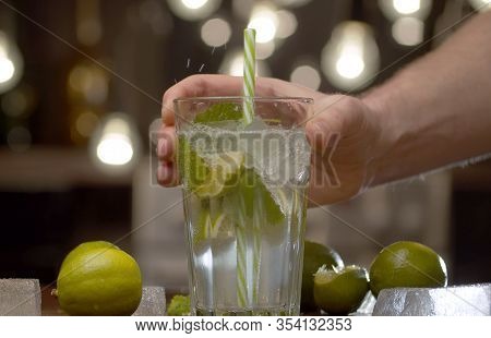 Male Hand Putting A Glass With A Tonic On The Table