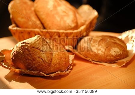 Different Buns Of Fresh Bread On A Brown Vintage Background. Freshly Baked Wheat Bread, Still Life W