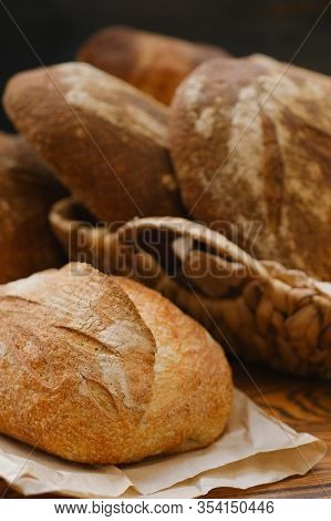 Different Buns Of Fresh Bread On A Brown Vintage Background. Freshly Baked Wheat Bread, Still Life W