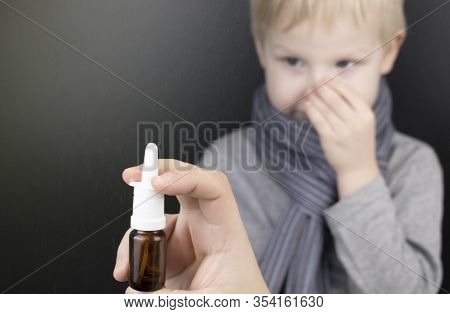A Runny Nose Is Treated With A Medicine From A Nasal Spray. Nasal Drops On A Black Background. Conce