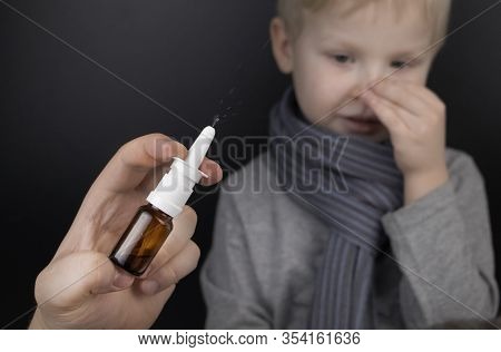 A Runny Nose Is Treated With A Medicine From A Nasal Spray. Nasal Drops On A Black Background. Conce