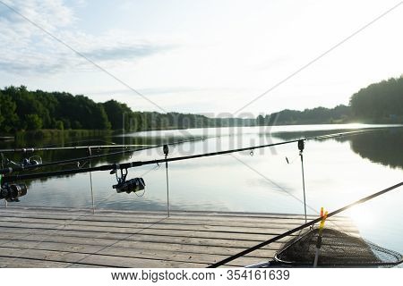 Carp Fishing On Beautiful Blue Lake With Carp Rods And Rod Pods In The Summer Morning. Fishing From 