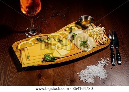 Assorted Different Types Of Cheese On A Wooden Board.