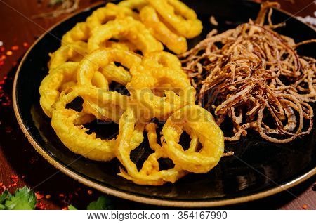 Fried Onion Rings Lie In A Black Plate Close-up