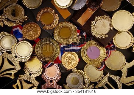 group of trophy and medals over blackboard background. top view. flat lay.Trophy is a specific achievement, serves as recognition / evidence of merit, awarded for sporting events