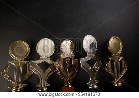 Golden trophy over blackboard background. top view. flat lay.Trophy is a specific achievement, serves as recognition / evidence of merit, awarded for sporting events