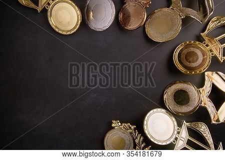 Golden trophy over blackboard background. top view. flat lay.Trophy is a specific achievement, serves as recognition / evidence of merit, awarded for sporting events