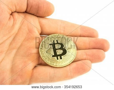 Bitcoin Coin Lies In The Palm Of Your Hand On A White Background