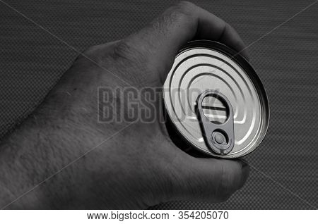 Closed Tin Can With Open Key In Hand. A Mans Hand Holds A Can Of Canned Food. Canned Foods. This Can