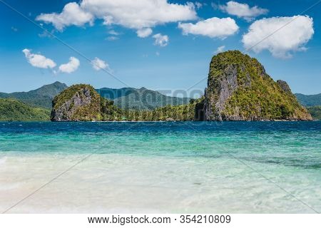 El Nido, Philippines. Crystal Clear Blue Water Lagoon And Private Malapacao Island In Background