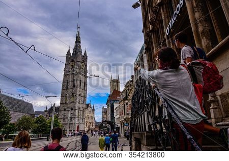 Ghent, Belgium, August 2019. The Bell Tower Called Beffroi Behind The Church Of St. Nicholas. A Tour