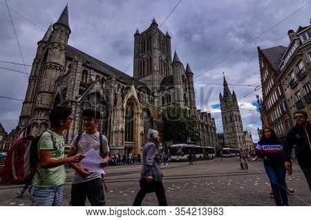 Ghent, Belgium, August 2019. Two Boys Consult The Tourist Map, Behind Them We Recognize The Church O