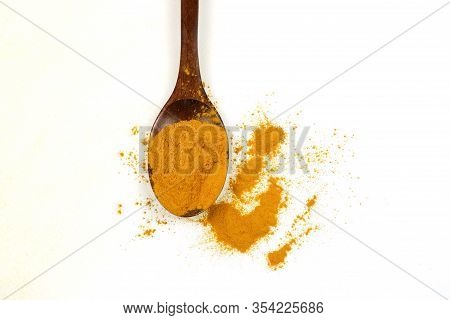 Turmeric Powder In A Wooden Spoon And Fresh Turmeric Roots Isolated On A White Background Is An Ingr