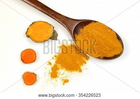 Turmeric Powder In A Wooden Spoon And Fresh Turmeric Roots Isolated On A White Background Is An Ingr