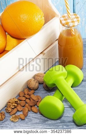 Lots Of Oranges, Dumbbells On A Wooden Textured Background. Fitness, Sports Nutrition.