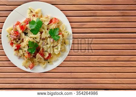 Pasta On A White Plate. Pasta Tomatoes, Onions, Cabbage On A Orange Wooden Background. Pasta With Ve