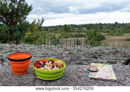 Snack Tourist On A Hike. Tourist Snack In A Silicone Plate. Map And Compass. Orient In Nature.