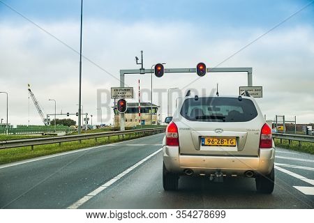 Den Oever, Netherlands - January 09, 2020. Cars Waiting On Traffic Lights Before Water Chanell