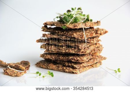 Homemade Vegetarian Seed And Nut Crackers. Crisp Flat Bread With Green Sprouts.