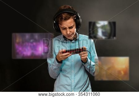A Teenage Boy With Bruises Under His Eyes, Tensely Playing A Computer Game. Transparent Screens With
