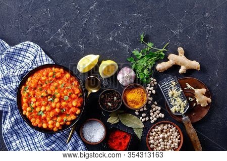 Indian Chana Masala Or Chickpea Curry With Ingredients On A Dark Concrete Background: Turmeric, Chil