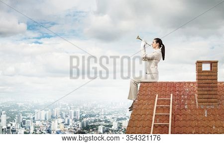 Attractive Young Woman Playing Music On Roof Of Building. Brave Businesswoman In White Business Suit