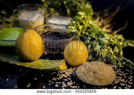 Face Mask For Acne And Blackheads On The Black Wooden Glossy Surface Consisting Of Some Cilantro Lea