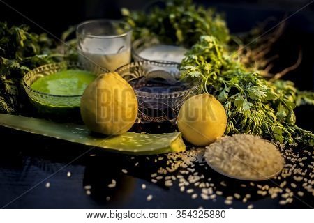 Face Mask For Acne And Blackheads On The Black Wooden Glossy Surface Consisting Of Some Cilantro Lea