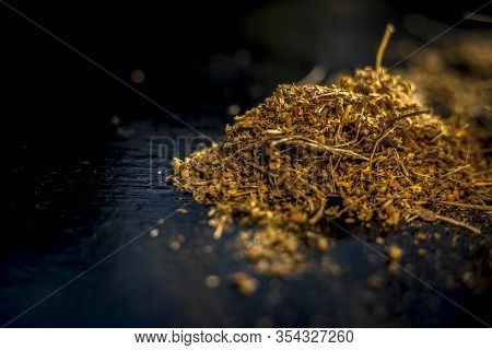 Close Up Of Shankhpushpi Roots On Wooden Surface Along With Some Of Its Powder With It. Shot With Bl
