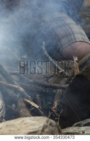 Trying For Fire. Smoke All Around And Pieces Of Wood.