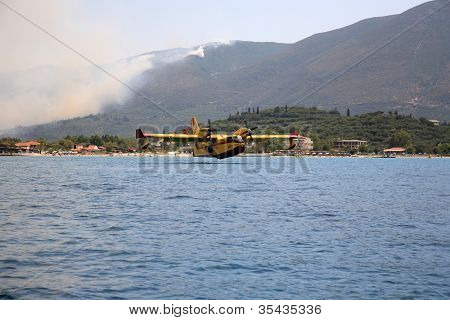 ZAKYNTHOS, Grécia - 1 de agosto: Canadair CL-415 ou Bombardier 415, aproximando-se do mar para tomar água durante