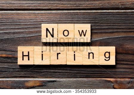 Now Hiring Word Written On Wood Block. Now Hiring Text On Wooden Table For Your Desing, Top View Con