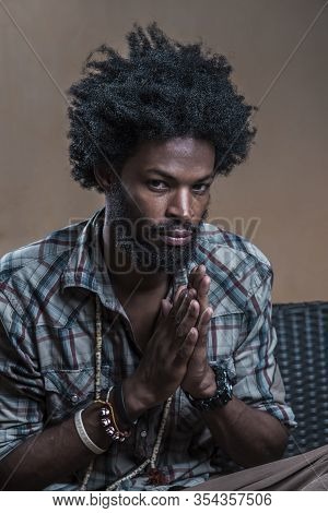 Portrait Of An Afro- Dominican In A Checkered Shirt Folded His Hands, Something In Mind
