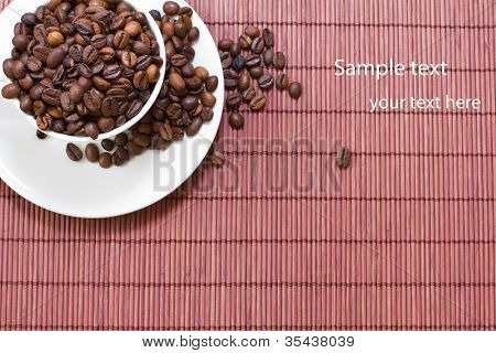 ถ้วยสีขาว มีเมล็ดกาแฟบนพื้นไม้
