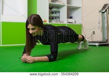 A Young Woman Doing Fitness Exercises In An Ems Suit. Concept: Health, Ems Training, Fitness In Ems 