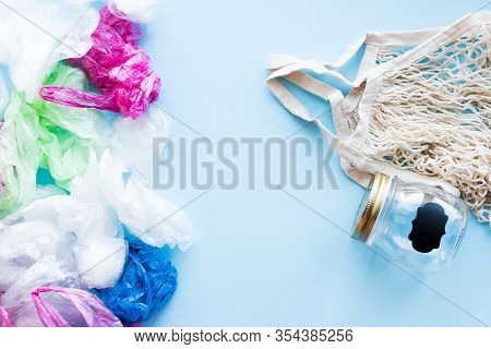 Many Disposable Plastic Bags Vs Reusable Cotton Bag And Glass Jar On A Blue Background. Zero Waste S