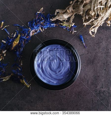Beautiful Photo Of Light Blue Skincare Product In Big Elegant Black Glass Container Surrounded By Dr